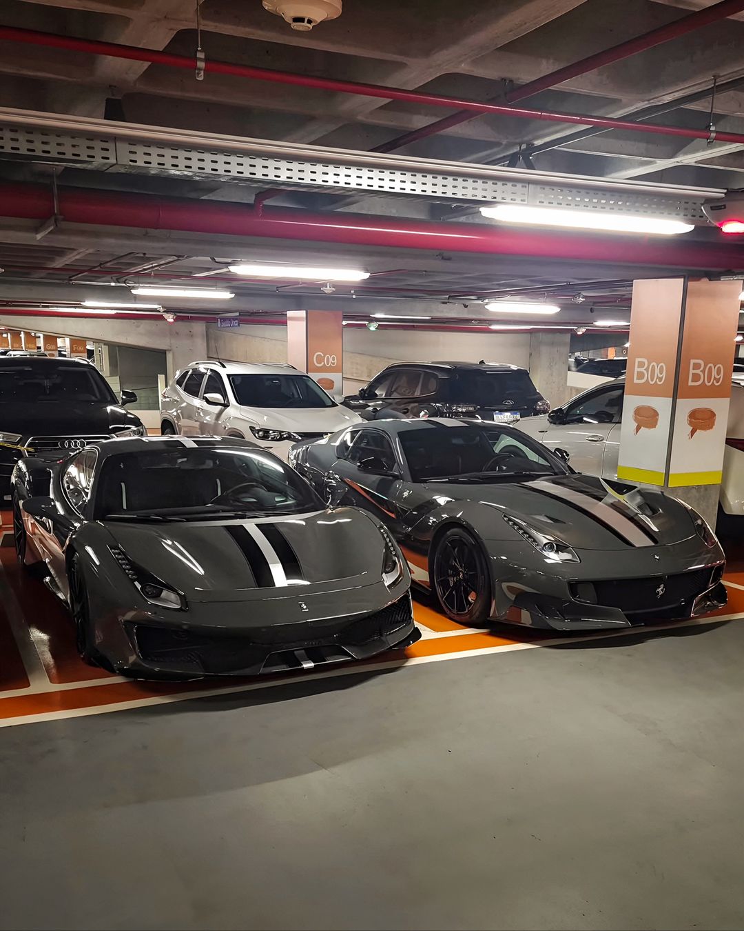 Ferrari 488 Pista e Ferrari F12tdf em Grigio Scuro lado a lado numa garagem de Curitiba