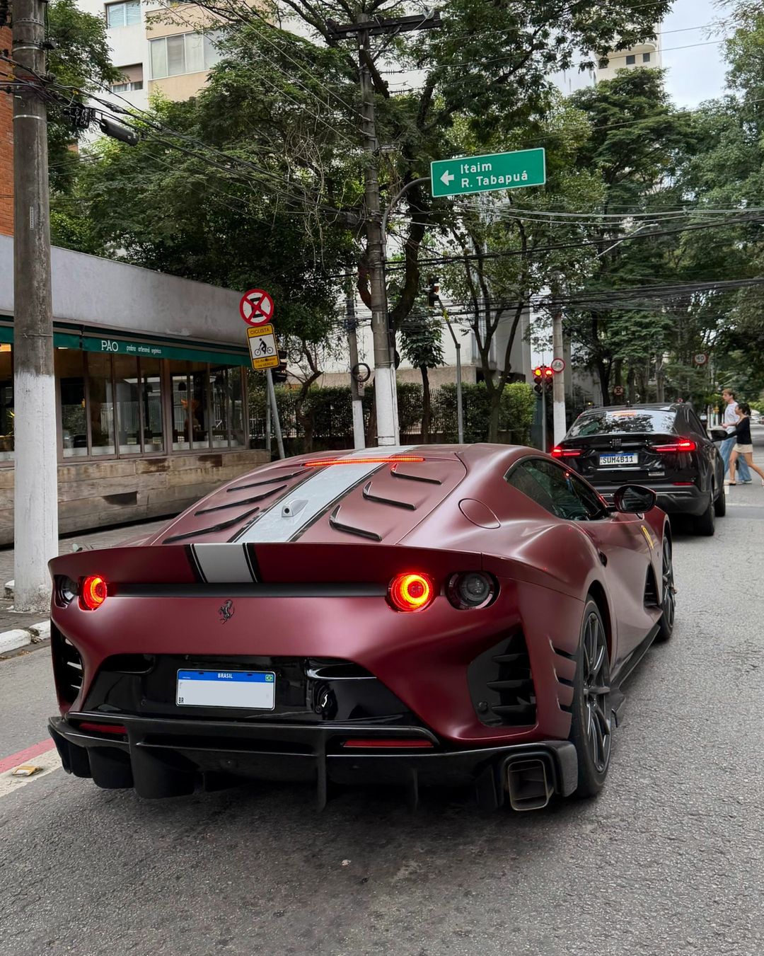 Ferrari 812 Competizione vermelha escura vista de trás numa rua de São Paulo