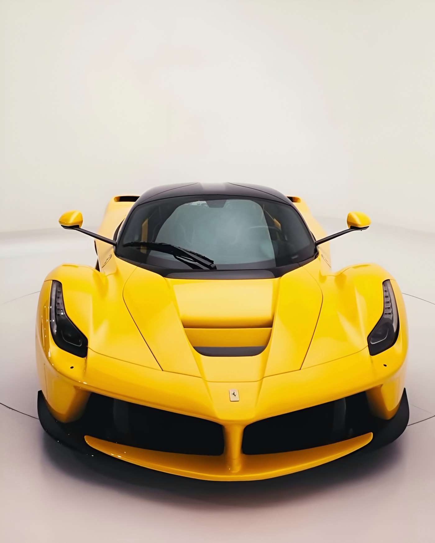 Ferrari LaFerrari amarela vista de frente num estúdio de fundo branco