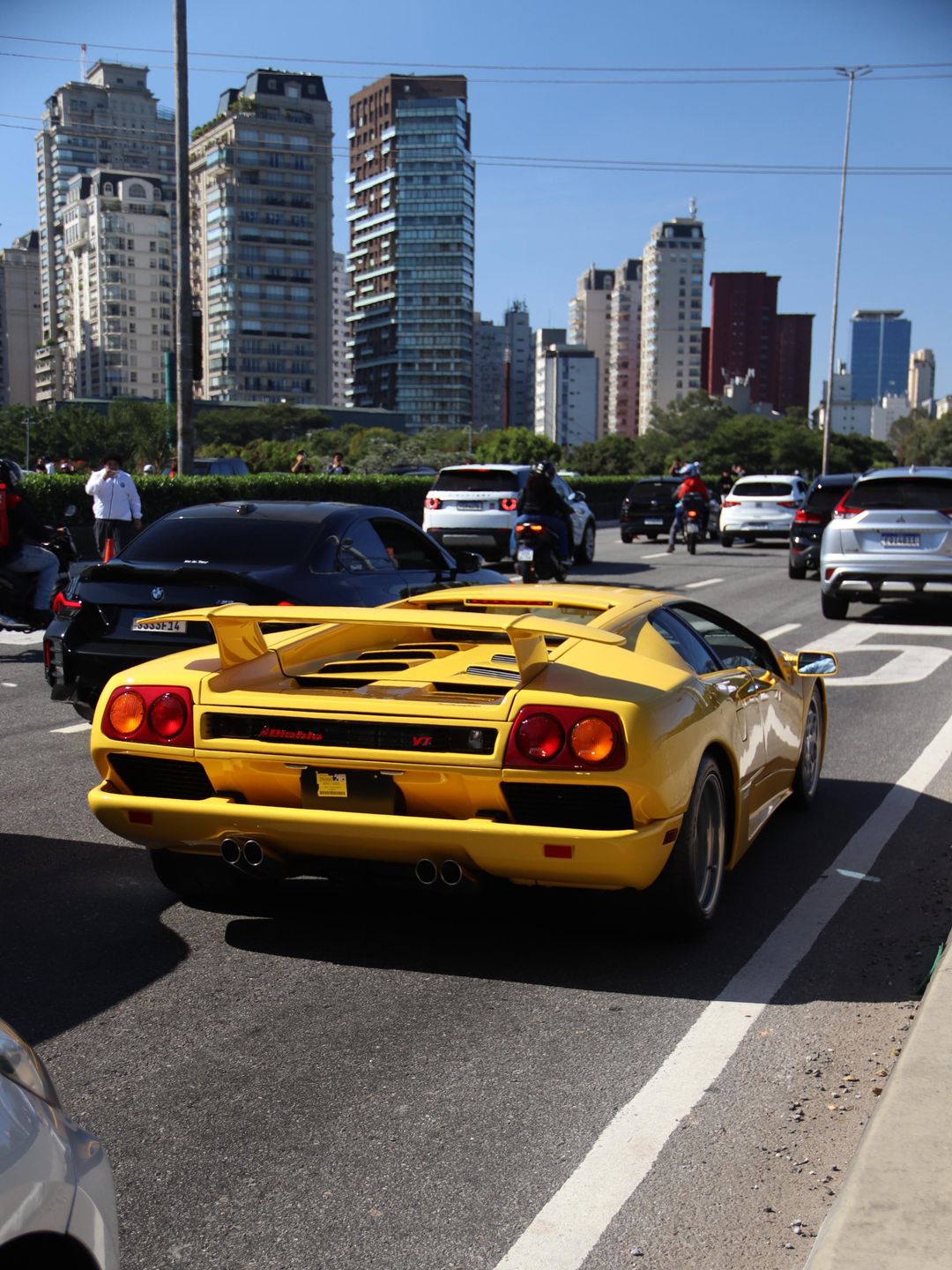 Lamborghini Diablo VT amarela numa avenida de São Paulo com prédios ao fundo