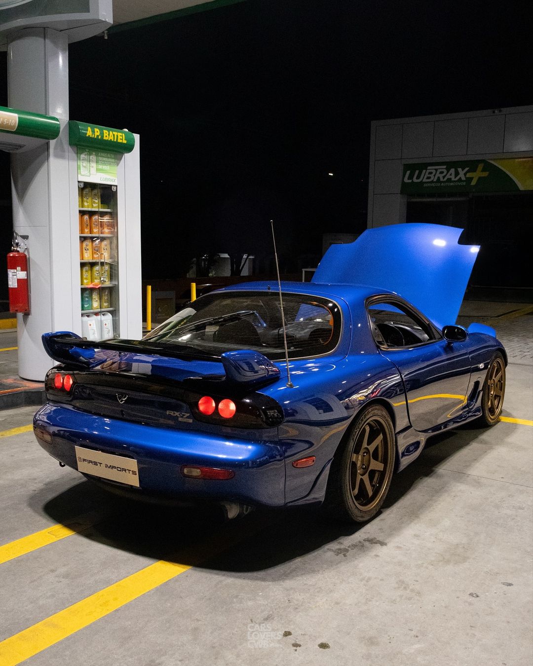 Mazda RX-7 FD azul de rodas douradas num posto à noite em Curitiba