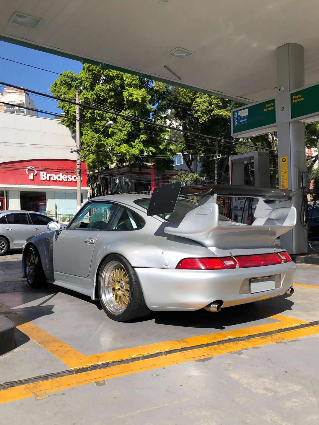 Porsche 911 Carrera 993 prata com rodas douradas num posto de São Paulo