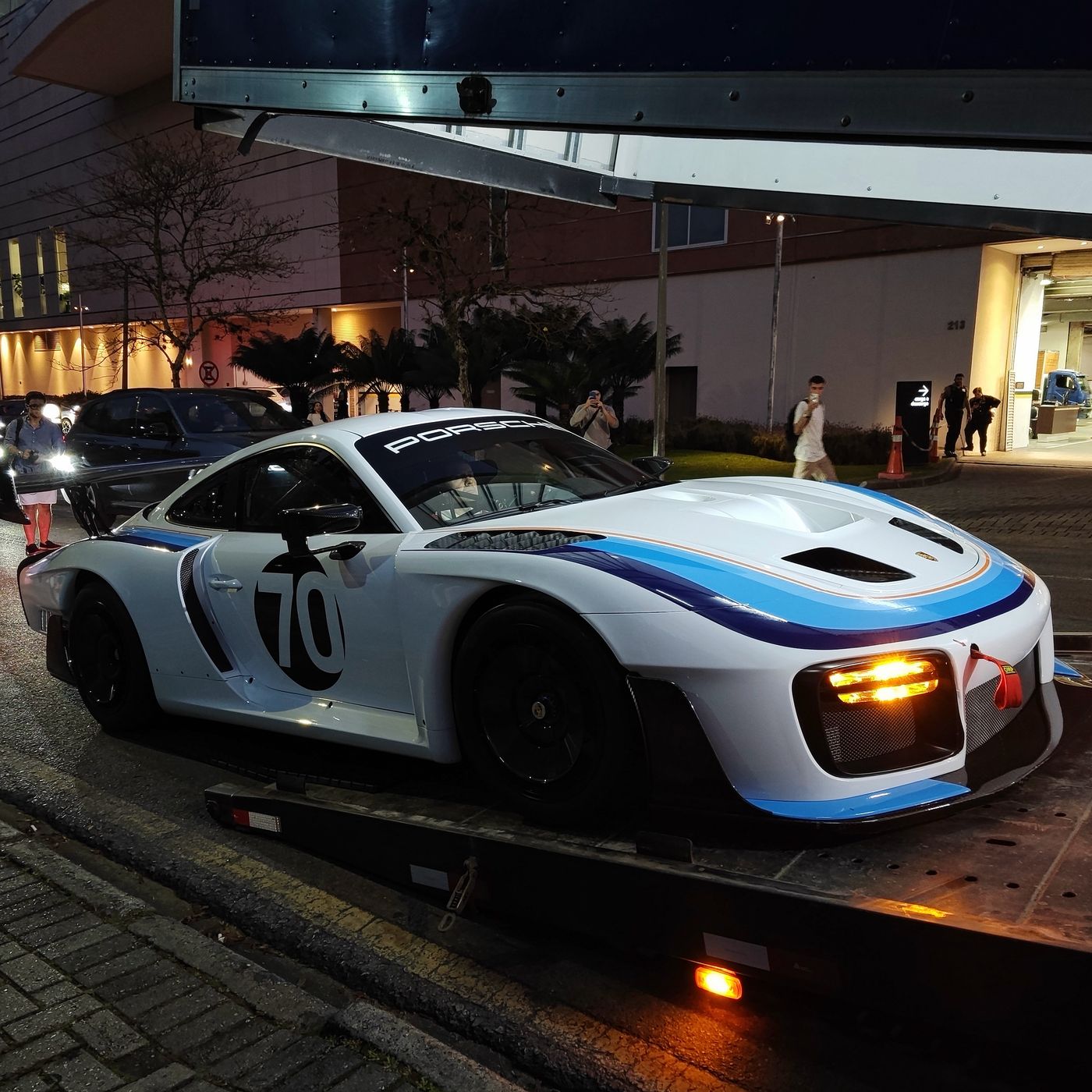 Porsche 935 moderno com pintura branca e azul de corrida e o número 70, à noite em Curitiba